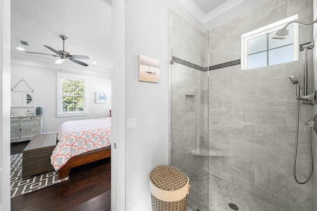 bathroom featuring hardwood / wood-style floors, ornamental molding, tiled shower, and ceiling fan