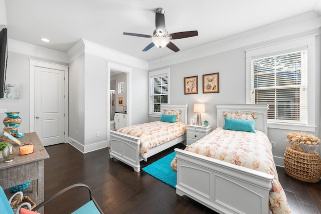 bedroom featuring ensuite bath, ornamental molding, dark hardwood / wood-style floors, and a fireplace