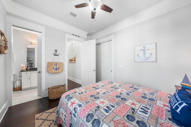 bedroom with a closet, ensuite bath, dark hardwood / wood-style floors, and ceiling fan