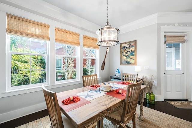 dining area featuring hardwood / wood-style flooring, ornamental molding, and a chandelier