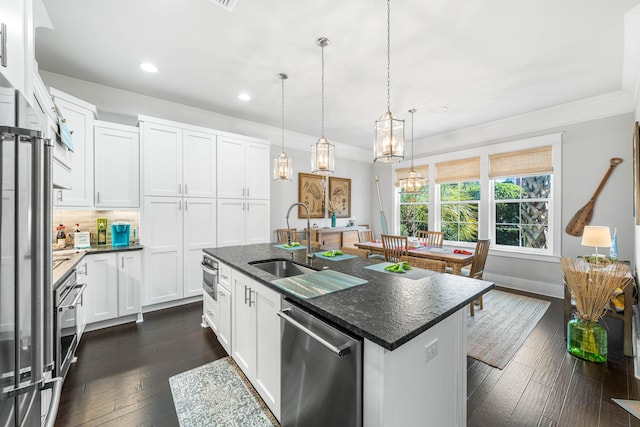 kitchen featuring pendant lighting, sink, an island with sink, white cabinets, and stainless steel dishwasher