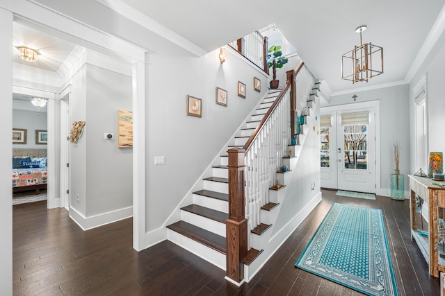 staircase featuring wood-type flooring, an inviting chandelier, and crown molding