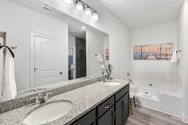 bathroom featuring wood-type flooring, independent shower and bath, and vanity