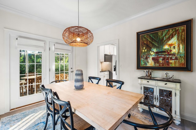 dining space featuring ornamental molding and wood-type flooring