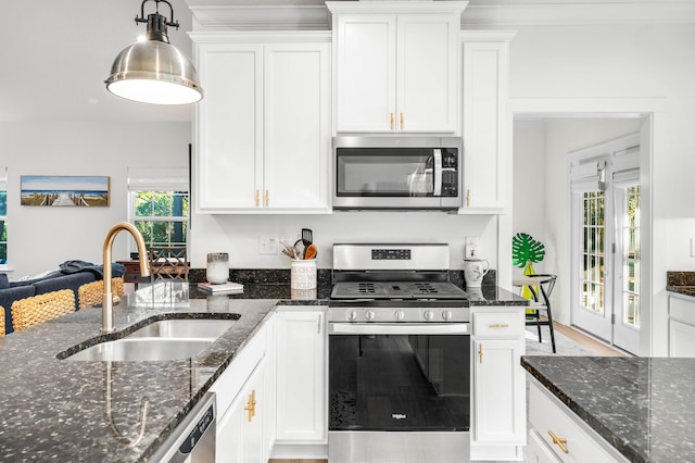 kitchen featuring a wealth of natural light, white cabinetry, sink, dark stone counters, and stainless steel appliances