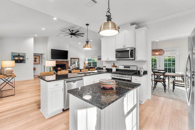 kitchen featuring hanging light fixtures, stainless steel appliances, a center island, and white cabinets