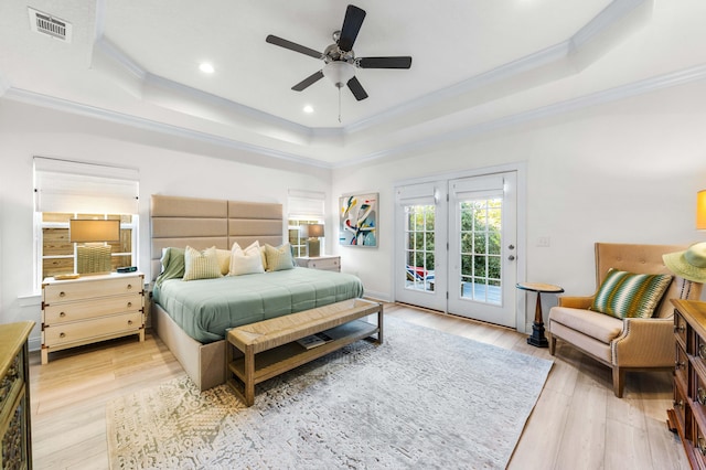 bedroom with crown molding, a tray ceiling, access to exterior, and light wood-type flooring