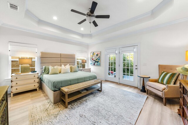 bedroom with crown molding, a tray ceiling, access to exterior, and light wood-type flooring