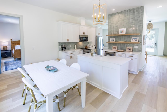 kitchen with white cabinetry, pendant lighting, tasteful backsplash, and stainless steel appliances