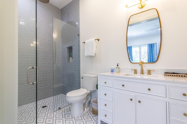 bathroom with an enclosed shower, vanity, and toilet