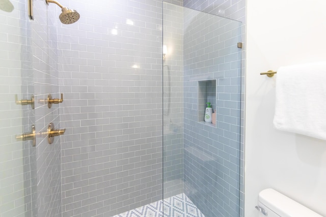 bathroom with toilet and tiled shower