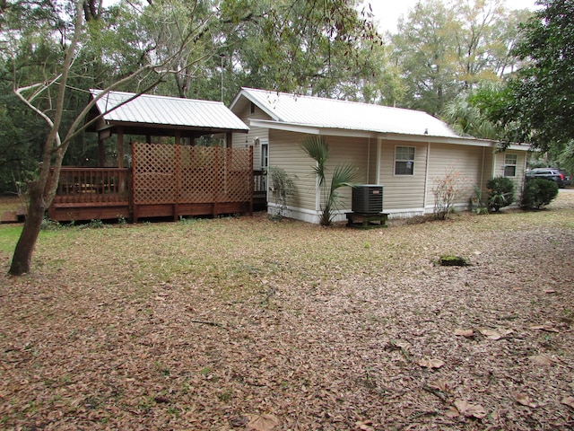 back of house with cooling unit and a deck