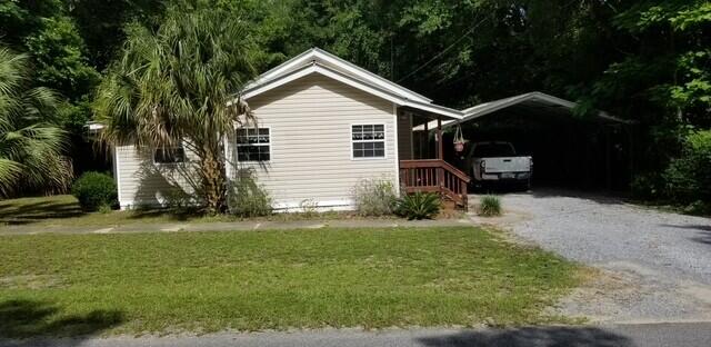 view of front facade featuring a carport and a front yard