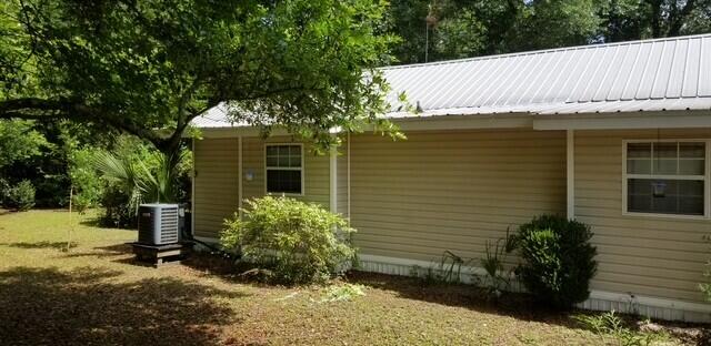 view of property exterior with a yard and central AC unit