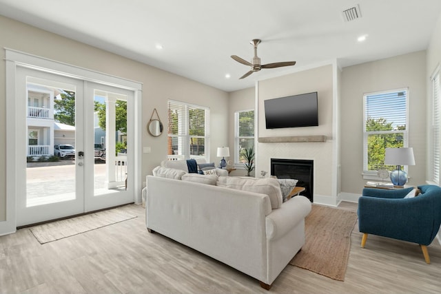 living room with ceiling fan, light wood-type flooring, and french doors