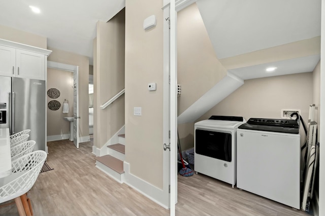 laundry room featuring light wood-type flooring and washer and clothes dryer