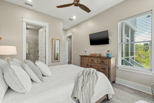 bedroom featuring connected bathroom, wood-type flooring, and ceiling fan