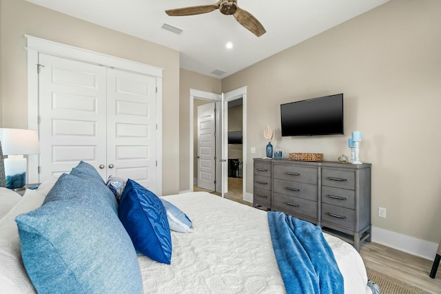 bedroom with ceiling fan, light hardwood / wood-style floors, and a closet