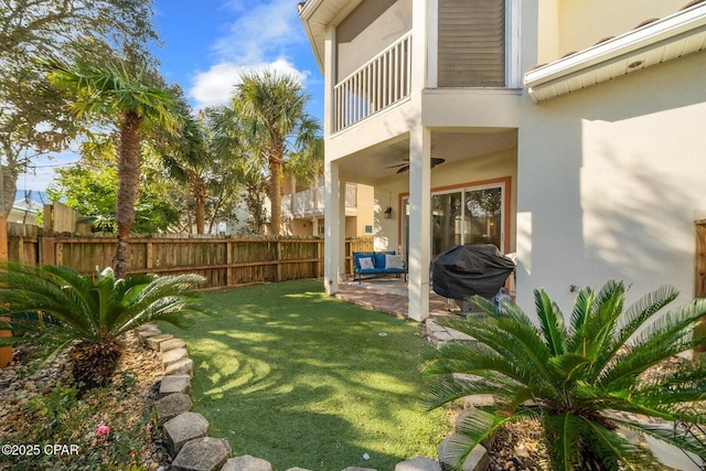 view of yard featuring ceiling fan, a balcony, and a patio