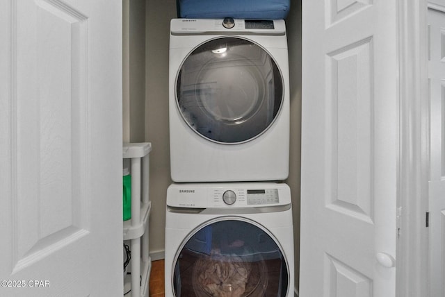 washroom featuring stacked washer / drying machine