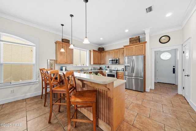 kitchen featuring stainless steel appliances, crown molding, pendant lighting, and kitchen peninsula