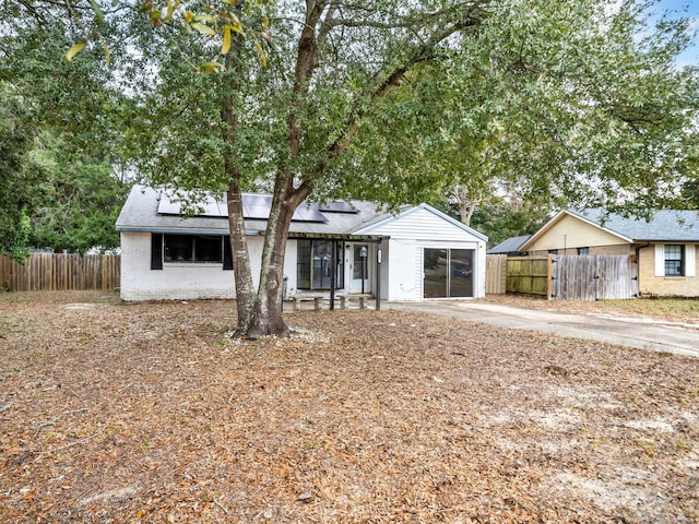 single story home featuring solar panels