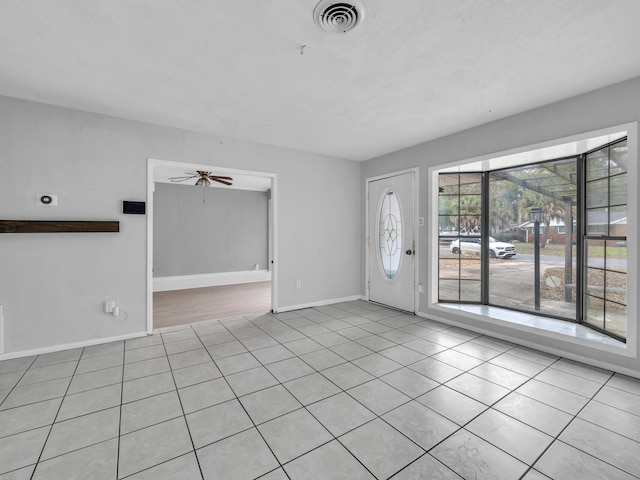 tiled entryway featuring ceiling fan