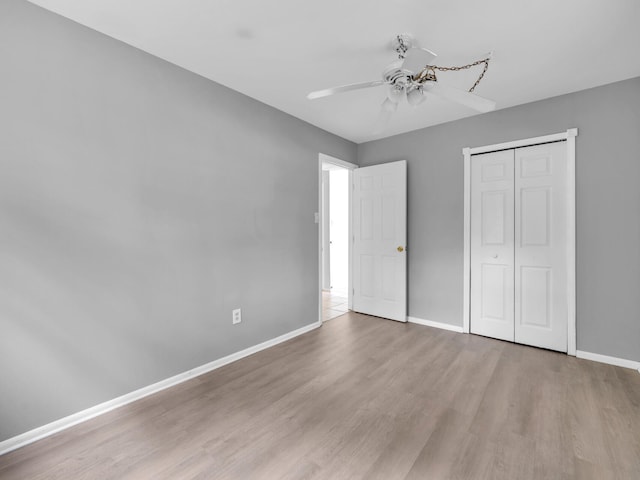 unfurnished bedroom featuring a closet, ceiling fan, and light wood-type flooring