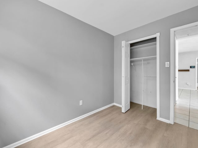 unfurnished bedroom featuring a closet and light wood-type flooring