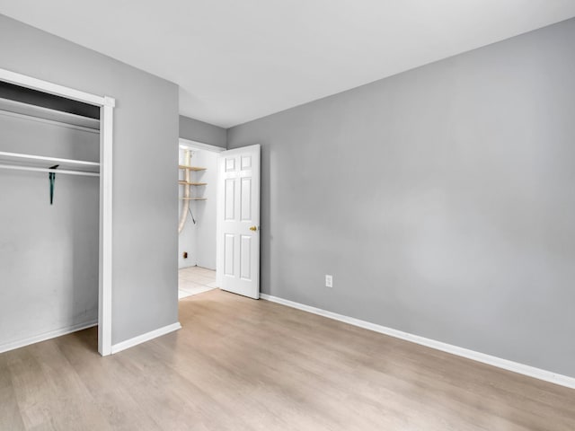 unfurnished bedroom with a closet and light hardwood / wood-style flooring