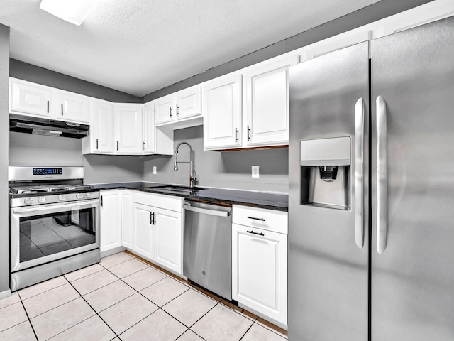 kitchen with sink, white cabinetry, stainless steel appliances, a textured ceiling, and light tile patterned flooring