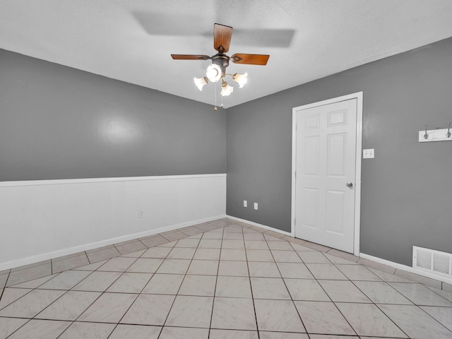 empty room featuring a textured ceiling and ceiling fan