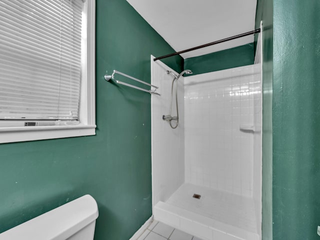 bathroom featuring tiled shower, tile patterned floors, and toilet