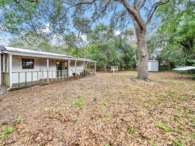 view of yard with covered porch and a shed