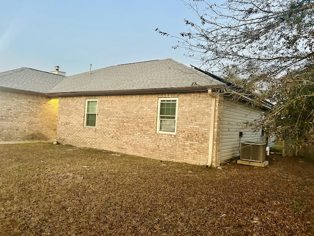 view of property exterior with cooling unit and a lawn