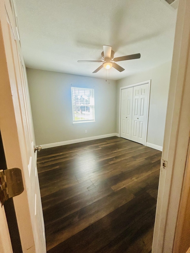 545 J H Crews Cir, Panama City, FL 32404 - unfurnished bedroom featuring baseboards, a ceiling fan, dark wood-style floors, and a closet