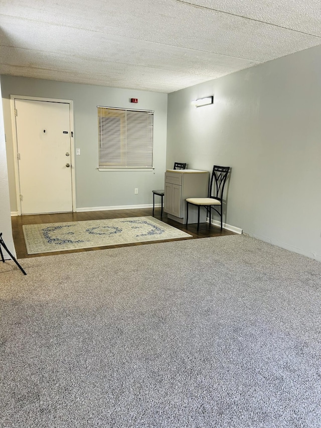 sitting room featuring carpet flooring and a textured ceiling