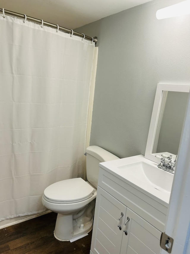 bathroom with wood-type flooring, toilet, and vanity