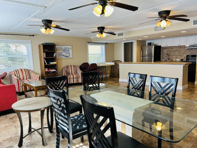 dining room with ornamental molding, sink, and a textured ceiling