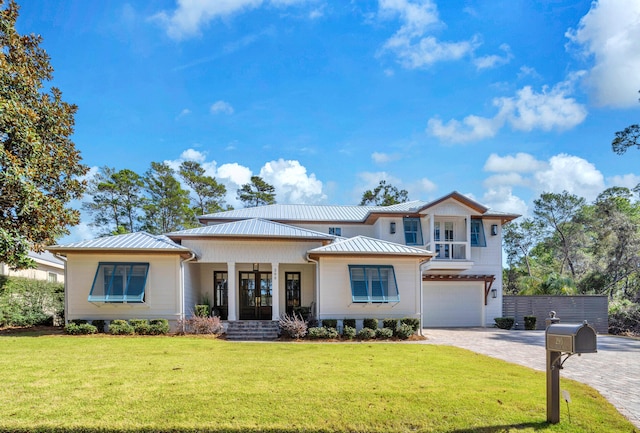 view of front of property featuring a garage, a front yard, and french doors