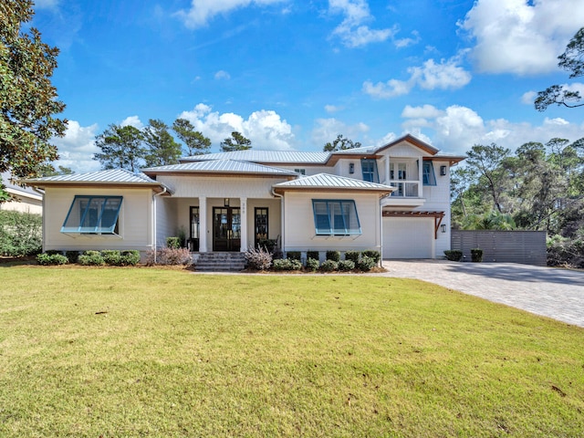 view of front of home with a garage, a front lawn, and a porch