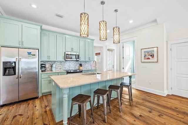 kitchen featuring pendant lighting, sink, stainless steel appliances, light stone countertops, and dark hardwood / wood-style flooring