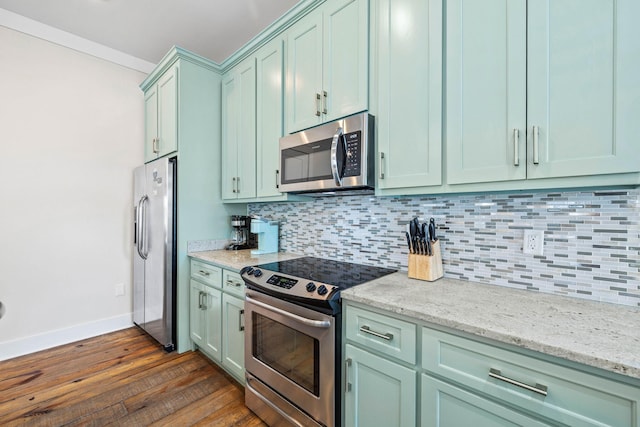 kitchen featuring light stone counters, stainless steel appliances, dark wood-type flooring, and backsplash