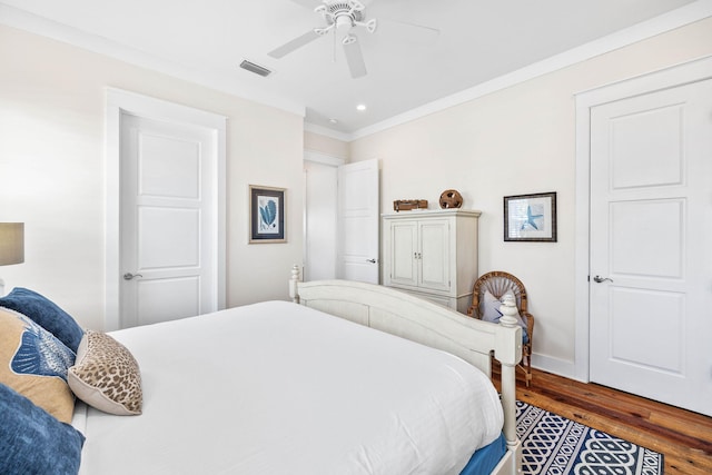 bedroom featuring dark hardwood / wood-style flooring, crown molding, and ceiling fan