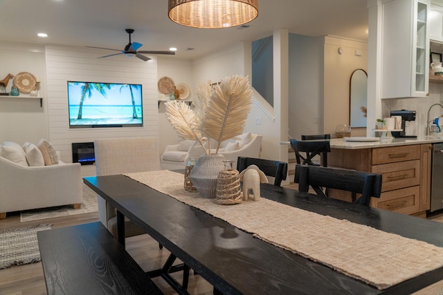 dining space featuring crown molding, ceiling fan, and light hardwood / wood-style flooring