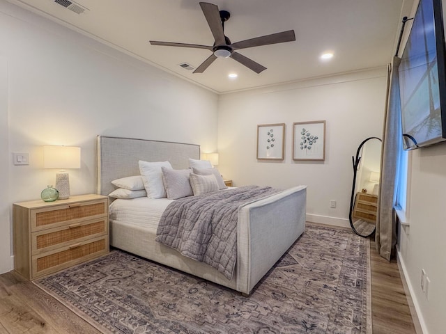 bedroom with hardwood / wood-style flooring, ornamental molding, and ceiling fan