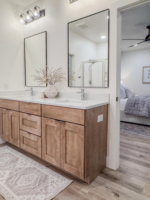 bathroom featuring walk in shower, ceiling fan, vanity, and hardwood / wood-style floors