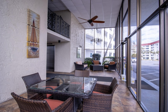 sunroom / solarium with a drop ceiling and ceiling fan