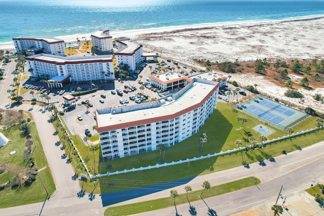 birds eye view of property with a water view and a beach view