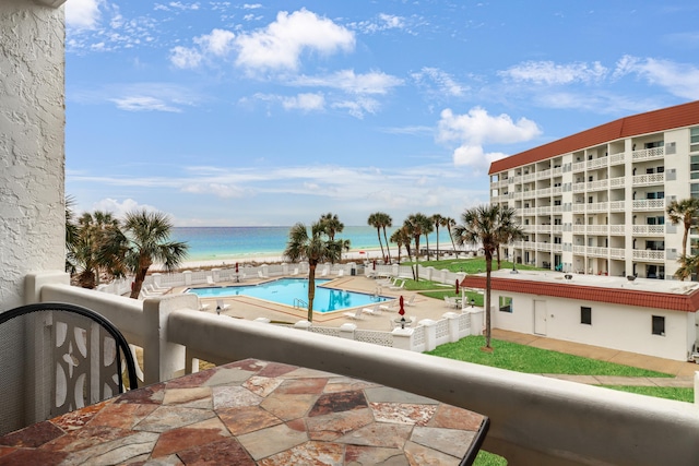 view of swimming pool featuring a water view and a view of the beach